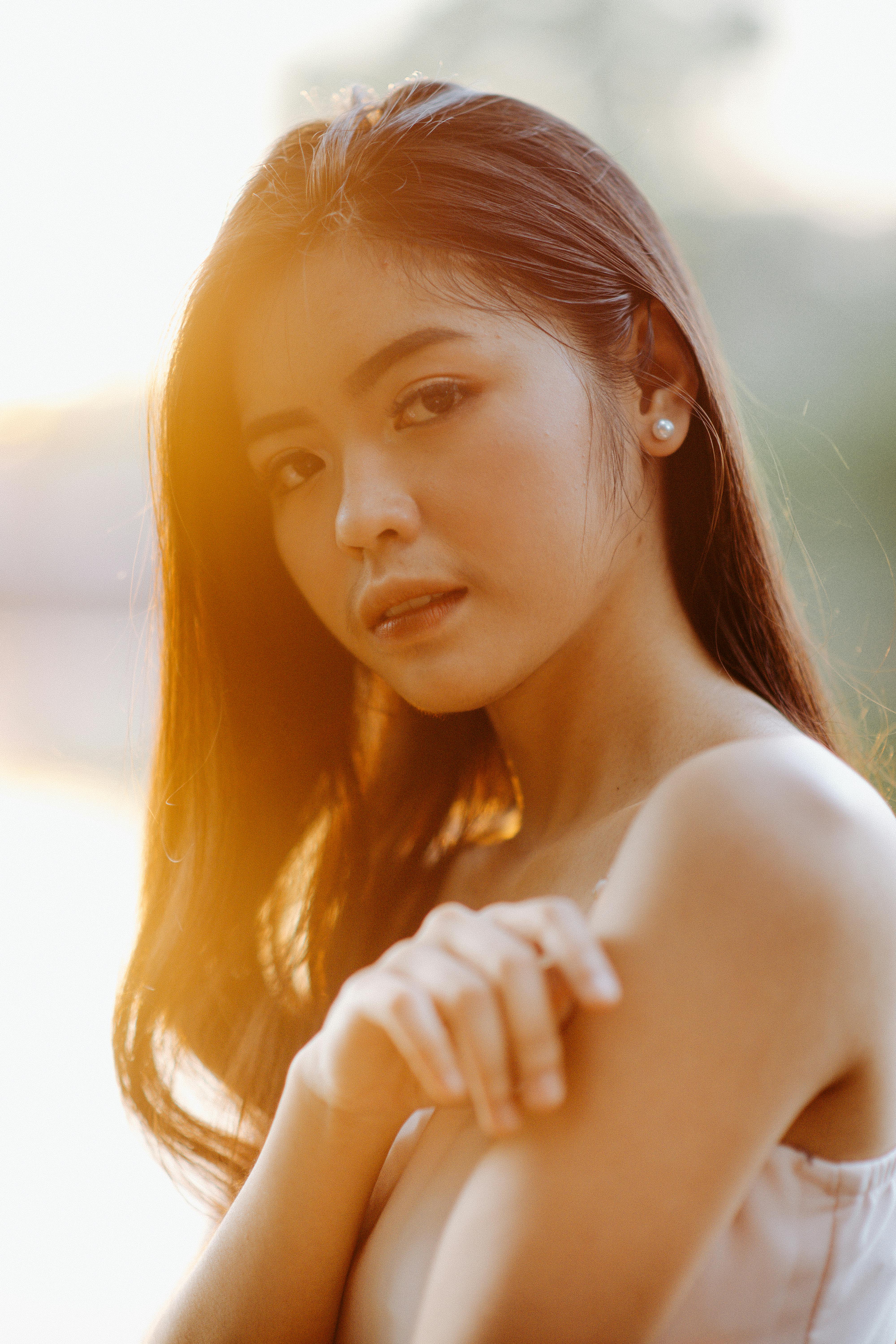 A serene portrait of a young woman in natural light during sunrise.
