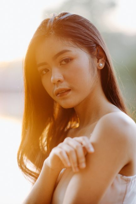 A serene portrait of a young woman in natural light during sunrise.