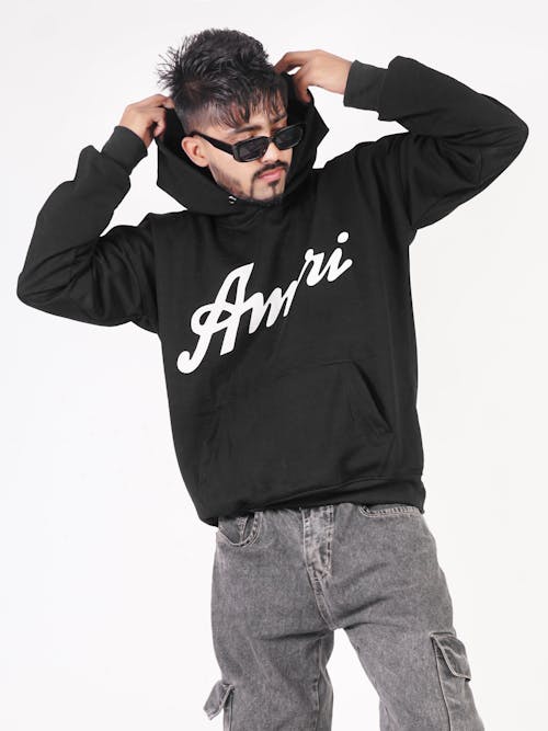 Model in a Black Hoodie with the Amiri Print Removing the Hood