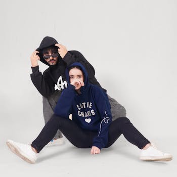 Trendy young adults wearing hoodies in a modern studio setting, showcasing urban style.