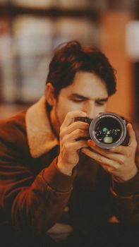 Professional photographer concentrating on camera settings indoors, showcasing passion for photography.