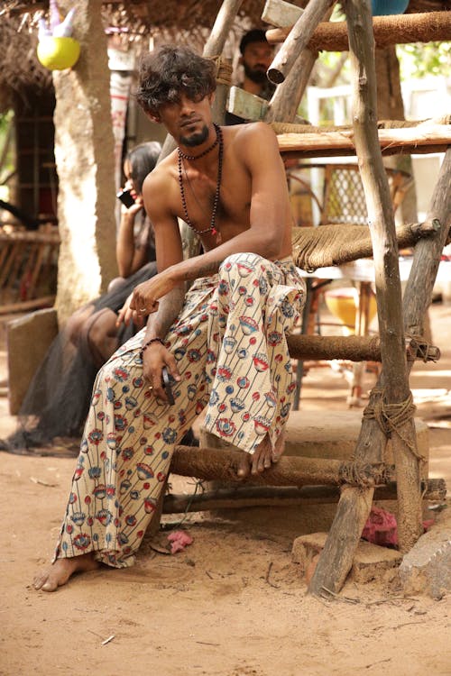 Shirtless Model Posing in Patterned Wide Pants