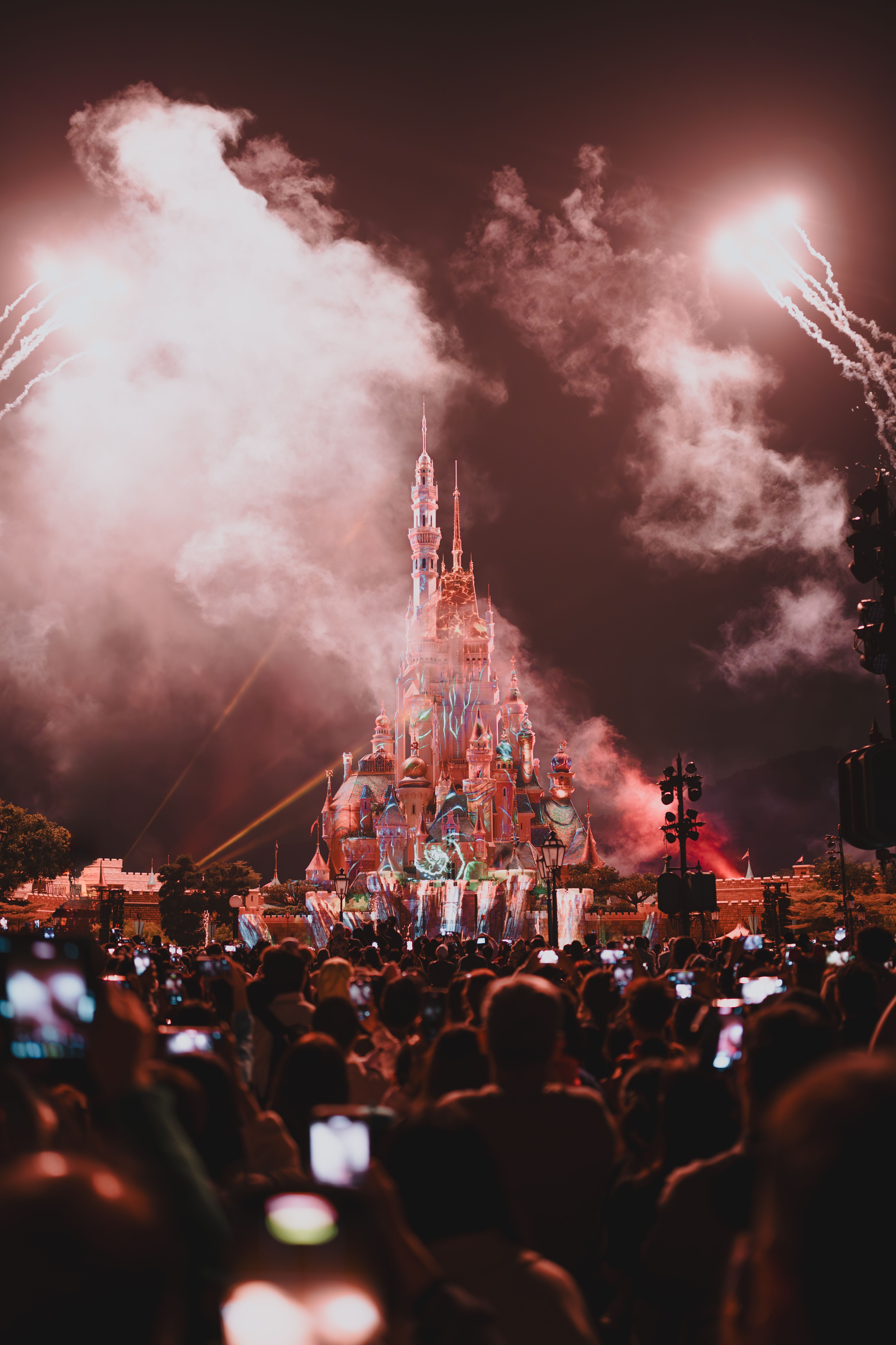 Spectacular fireworks illuminate the night sky above Hong Kong Disneyland castle, captured at a vibrant event.