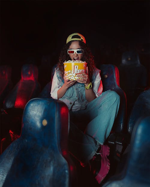 Woman Sitting with Popcorn at Cinema