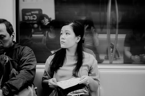 Woman Sitting on Metro Train in Black and White