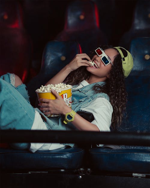 Smiling Woman Eating Popcorn at Cinema
