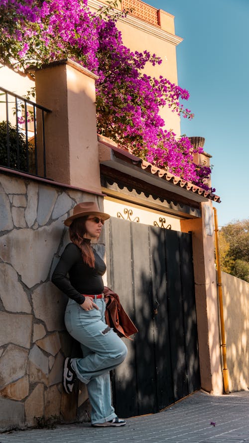 Woman in Hat Standing by Wall in Spring