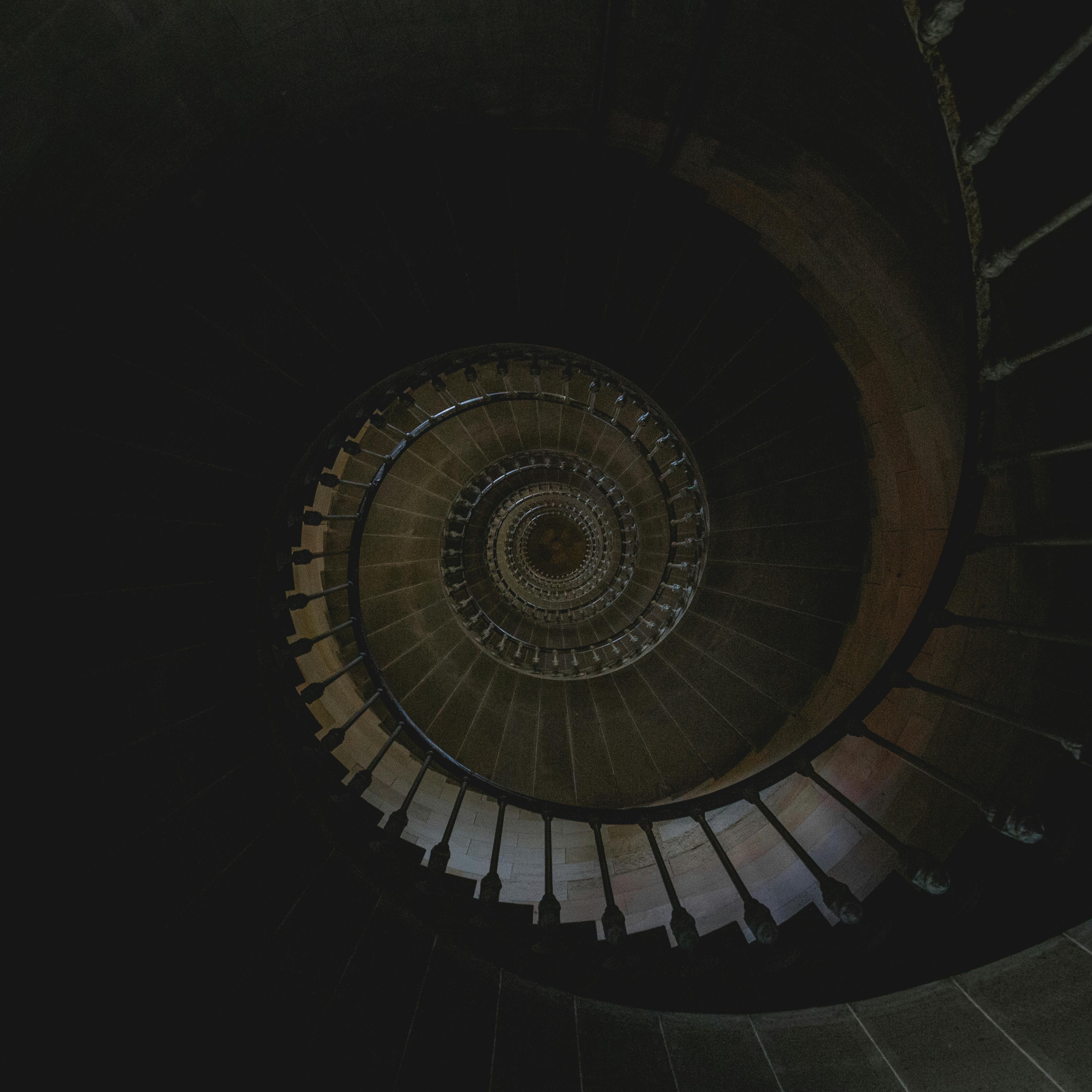 Captivating aerial shot of a spiral staircase with a mysterious dark ambiance.