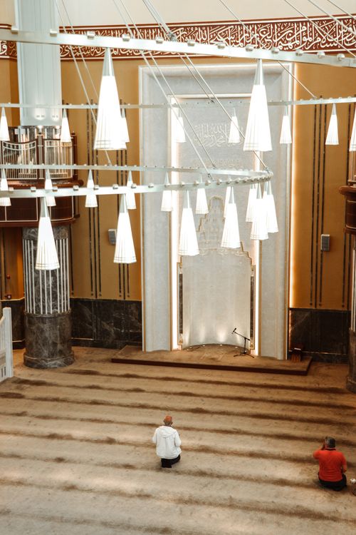 Free Two men praying inside a mosque in Istanbul, capturing the serene atmosphere and architectural details. Stock Photo