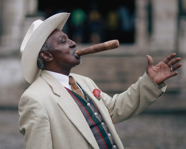 Man Wearing Hat, Suit And Smoking Cigar