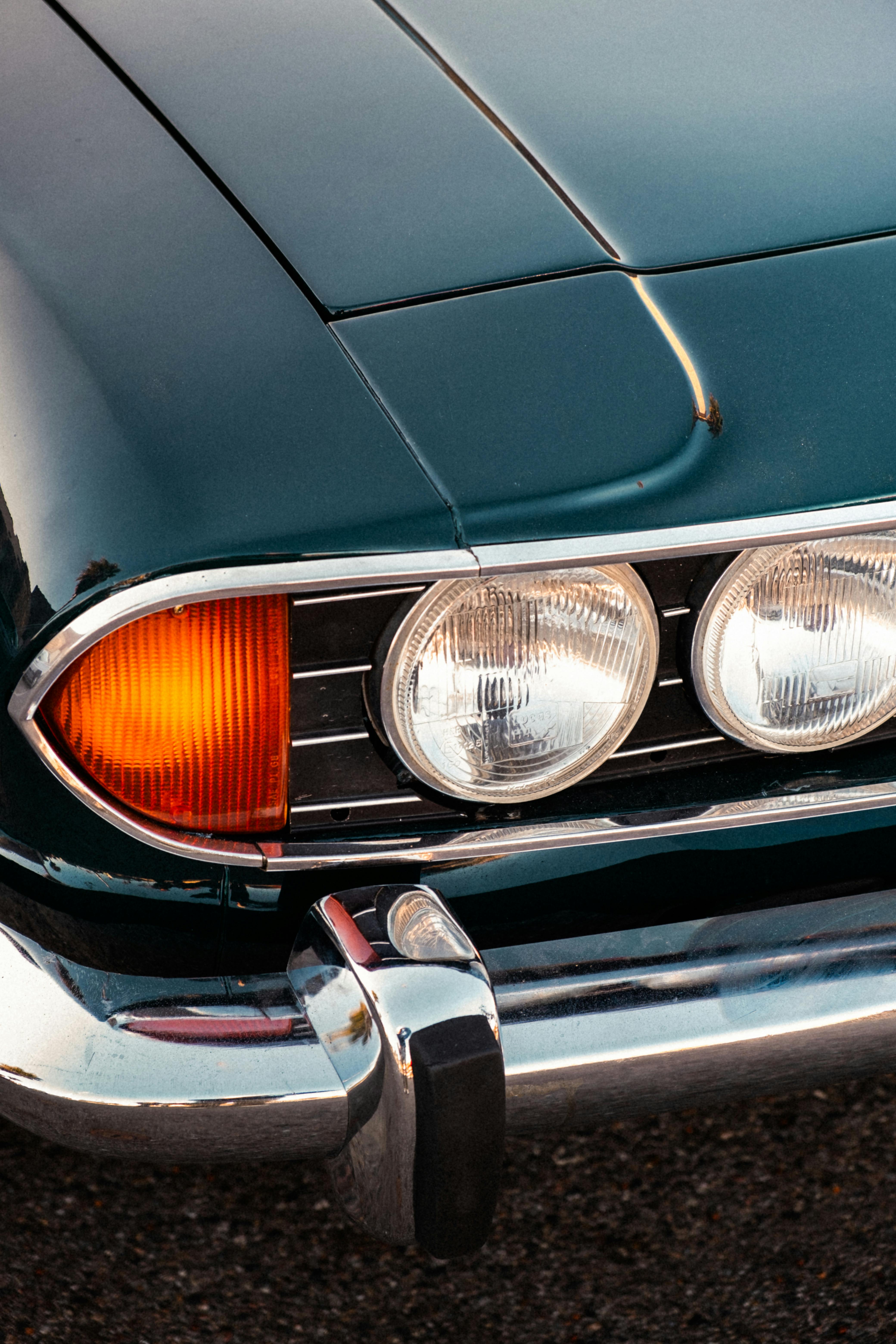 Close-up of a vintage car's front, featuring chrome and retro design elements.