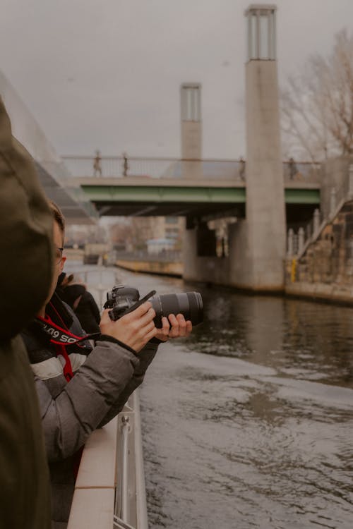 Person with Camera Taking Pictures over River