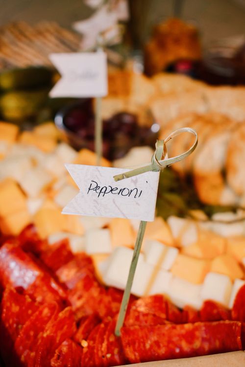 Free Close-up of a pepperoni and cheese platter with decorative label tags, perfect for events or casual dining. Stock Photo