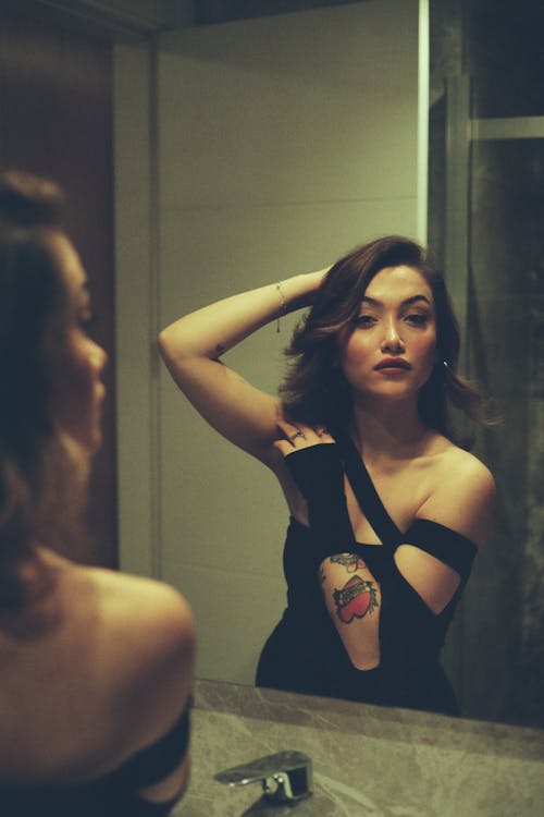 Brunette Woman Looking at Herself in a Mirror
