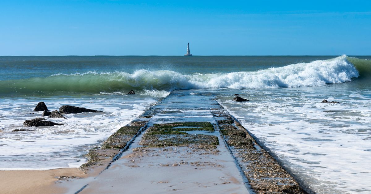 Wave Washing View of a Wave Washing up the Shore and a Lighthouse in Distance · Free ...