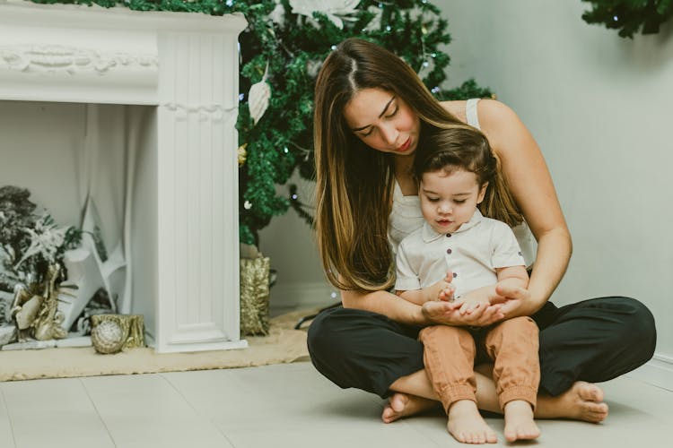 Woman With Her Baby In Front Of A Christmas Tree 