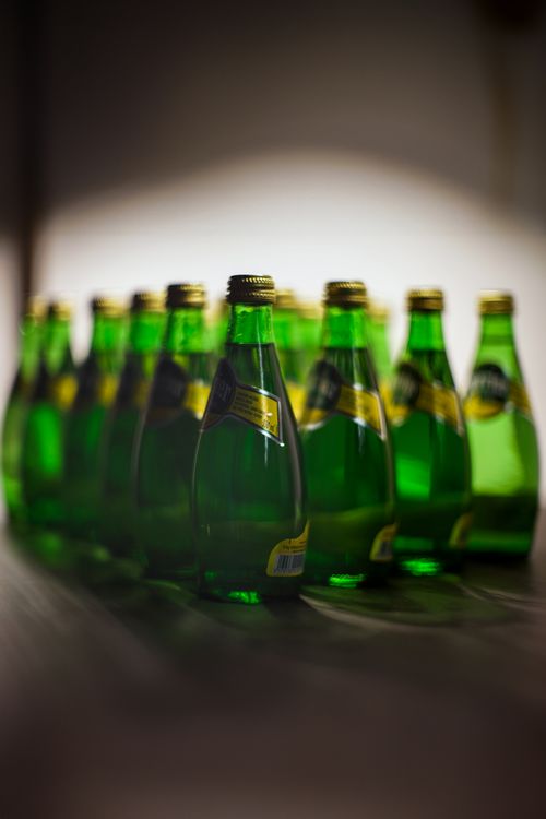 Free Abstract image of vibrant green glass bottles arranged in a row with soft lighting and focus. Stock Photo
