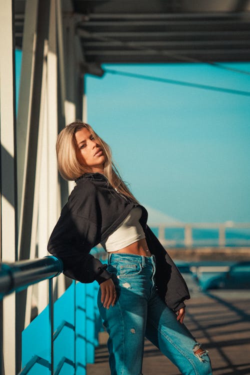 Model in a Black Cropped Blouse on a White Crop Top and Distressed Jeans