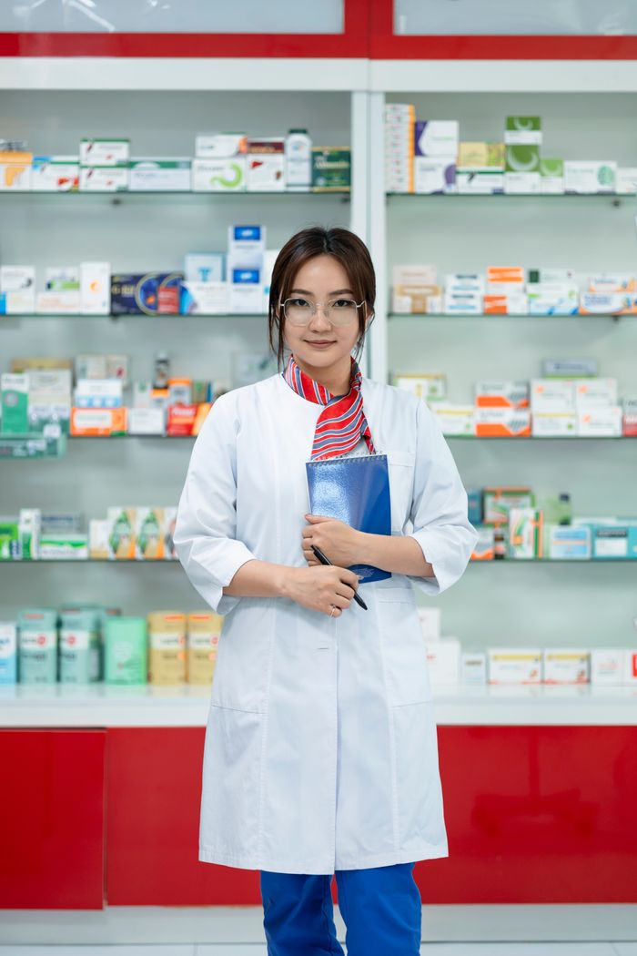 Pharmacienne debout dans une officine bien organisée