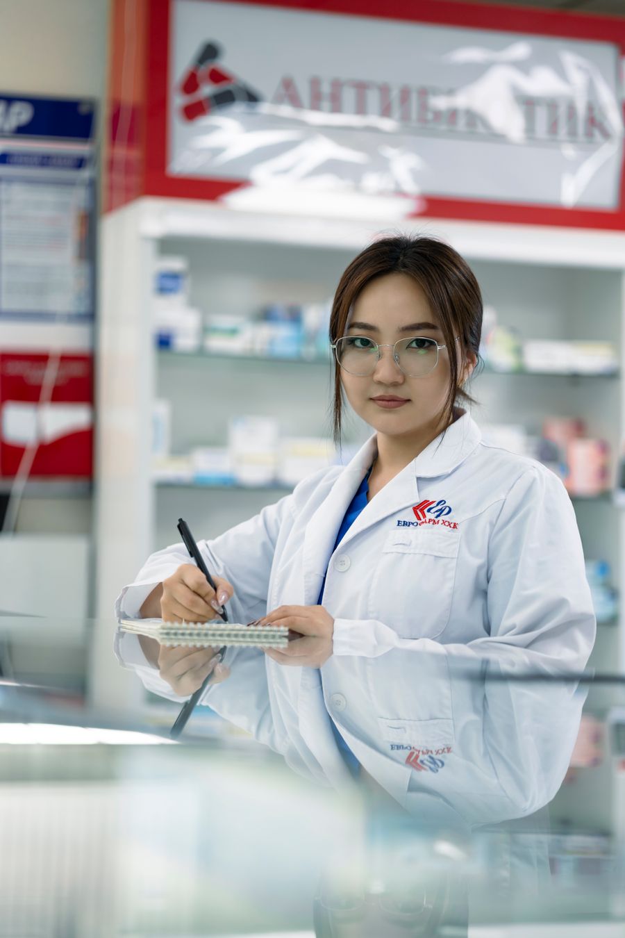 Pharmacienne notant les conseils d'un traitement à l'officine