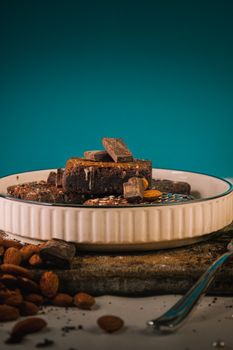 A plate of rich chocolate brownies adorned with almonds, perfect for dessert lovers.