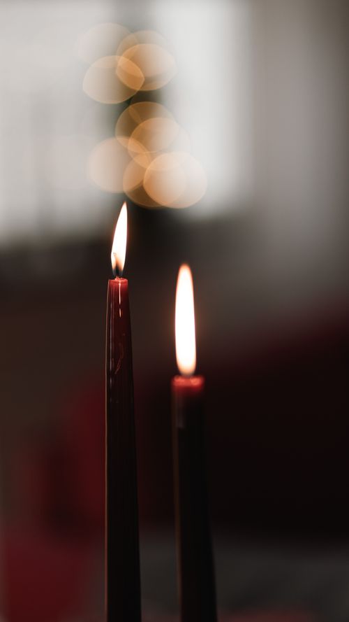 Free A pair of elegant candles with soft flames creating a warm Christmas ambience indoors. Stock Photo