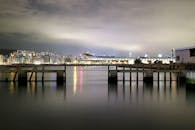 香港岛海滨的夜晚城市景观中，一座桥倒映在水中