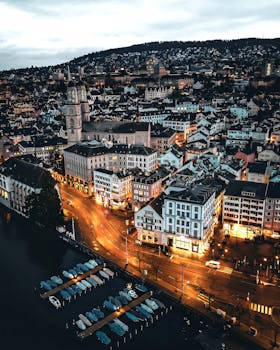 Stunning aerial view of Zürich, Switzerland, showcasing illuminated streets and iconic landmarks at twilight.