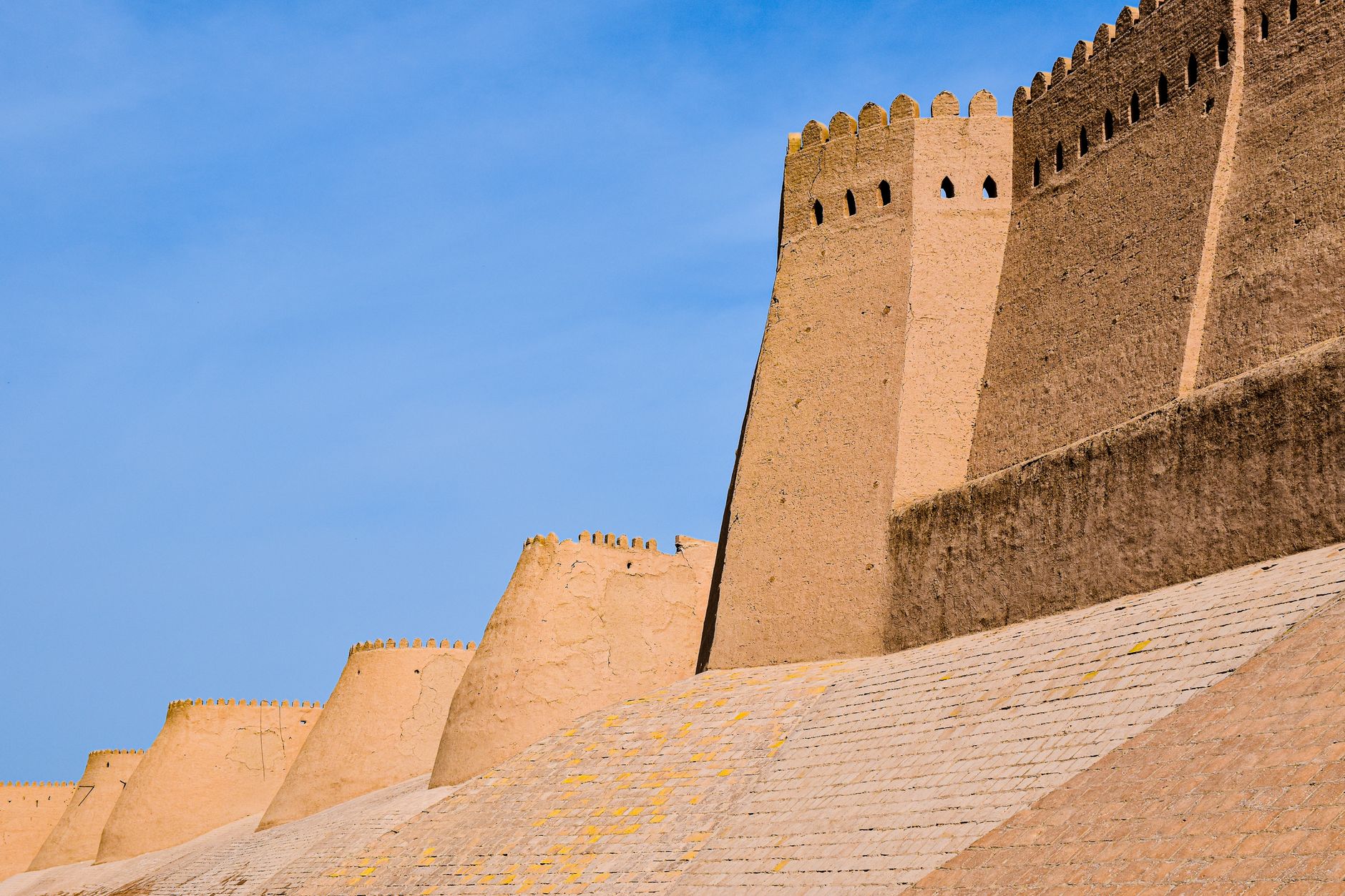 Historic walls of Ichan Kala in Khiva, Uzbekistan, under a clear blue sky.