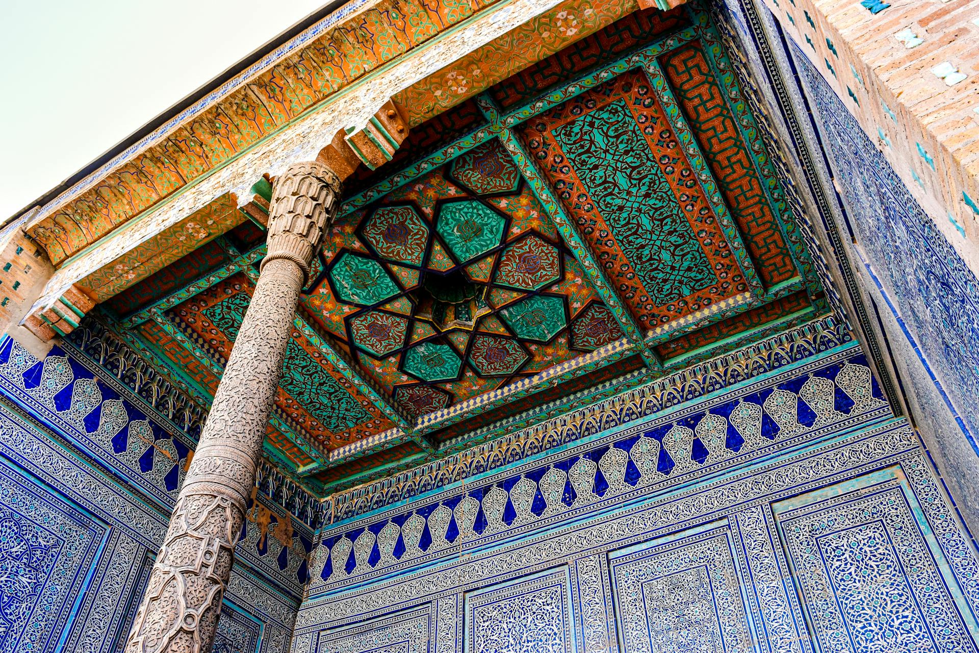 The intricate and vibrant ceiling of Toshhovli Palace in Khiva, showcasing traditional Uzbek architecture.