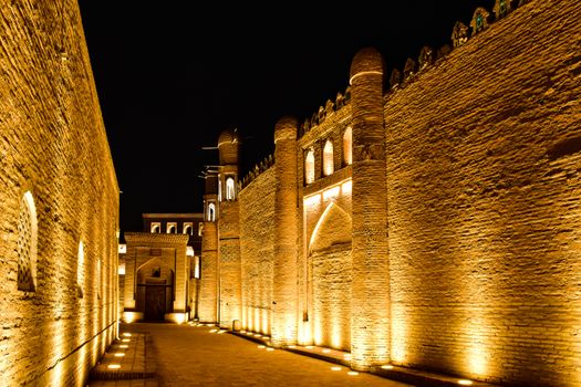 Capture the beauty of ancient illuminated walls at night in Khiva, Uzbekistan's old town.