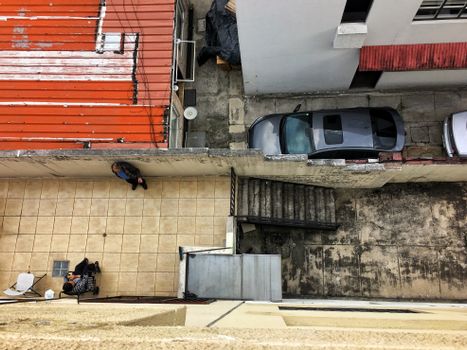 Aerial view of urban courtyard with two people and parked cars.