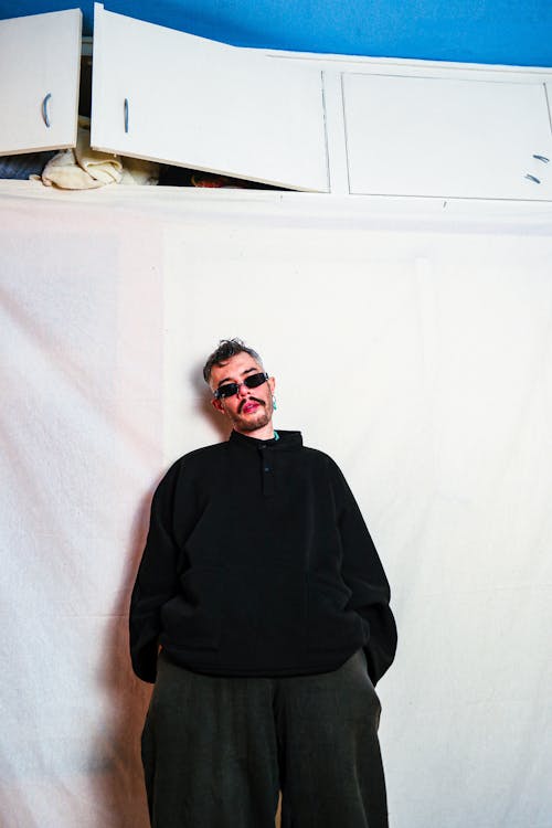 Man Posing against a White Sheet 