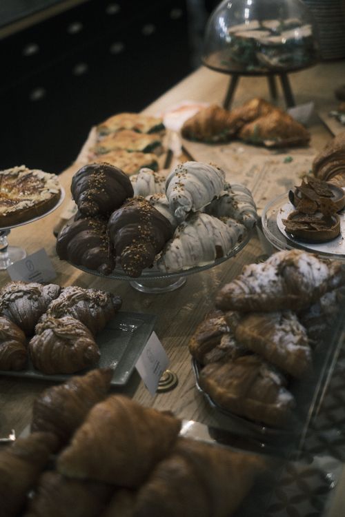 Free Assorted pastries and croissants on display in a cozy bakery setting. Stock Photo
