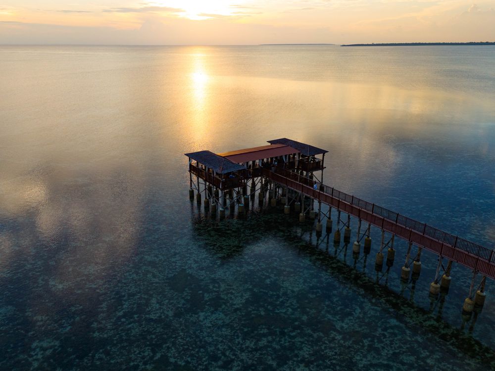 View Off Pier Aerial View of a Pier on the Shore with Clear Water in the Evening ...