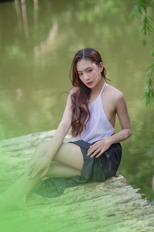 Attractive Brunette Posing in Blouse and Skirt by Lake