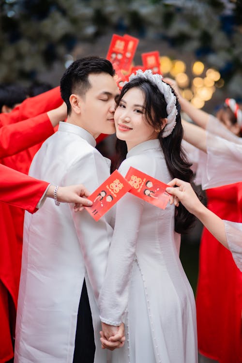 Groom Kisses the Bride During a Traditional Vietnamese Wedding