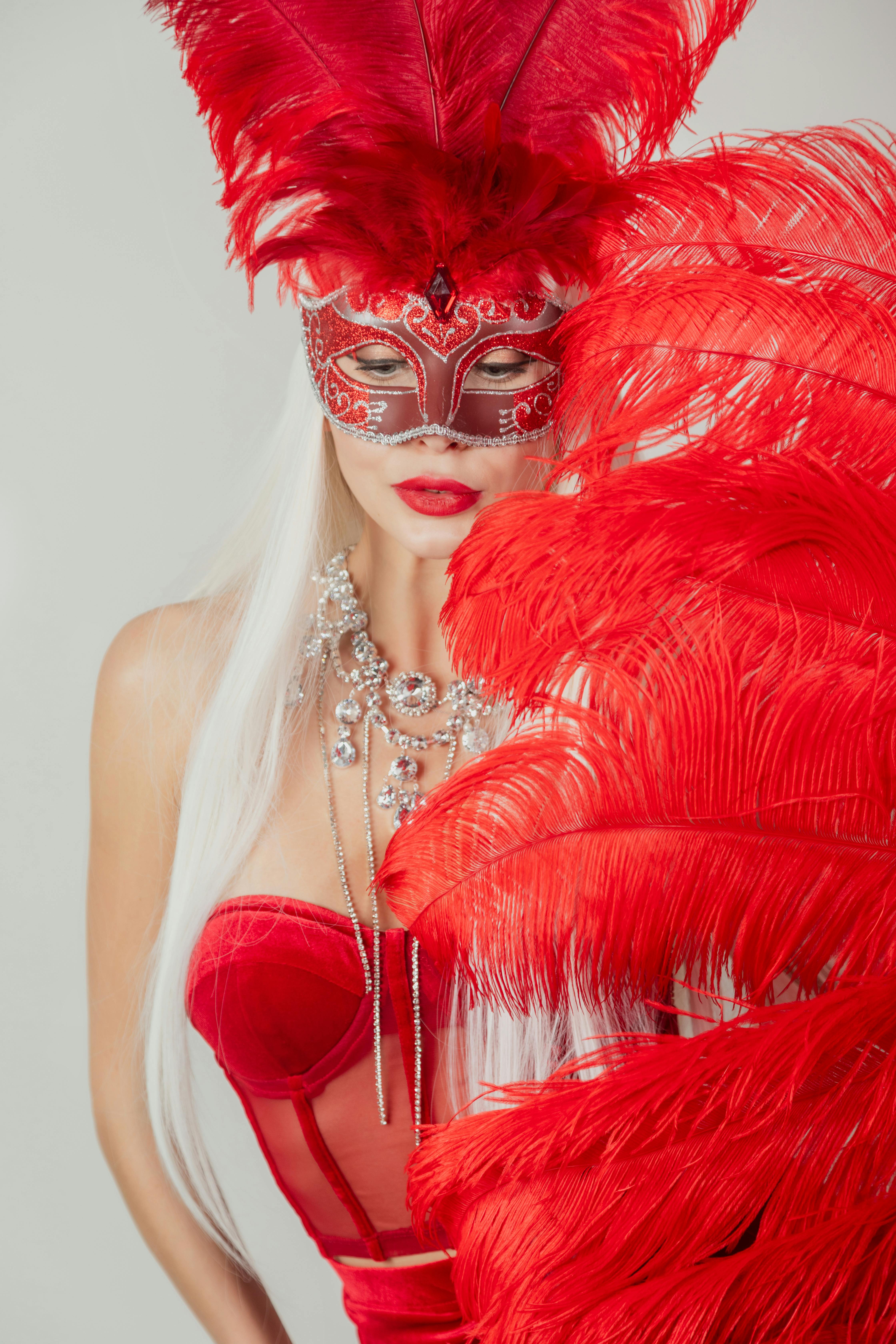 woman posing in a red costume with feathers