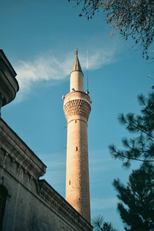 Free A vertical shot of a historic mosque minaret with a clear blue sky background, exemplifying Islamic architecture. Stock Photo