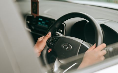 Close-up of hands holding a steering wheel inside a car