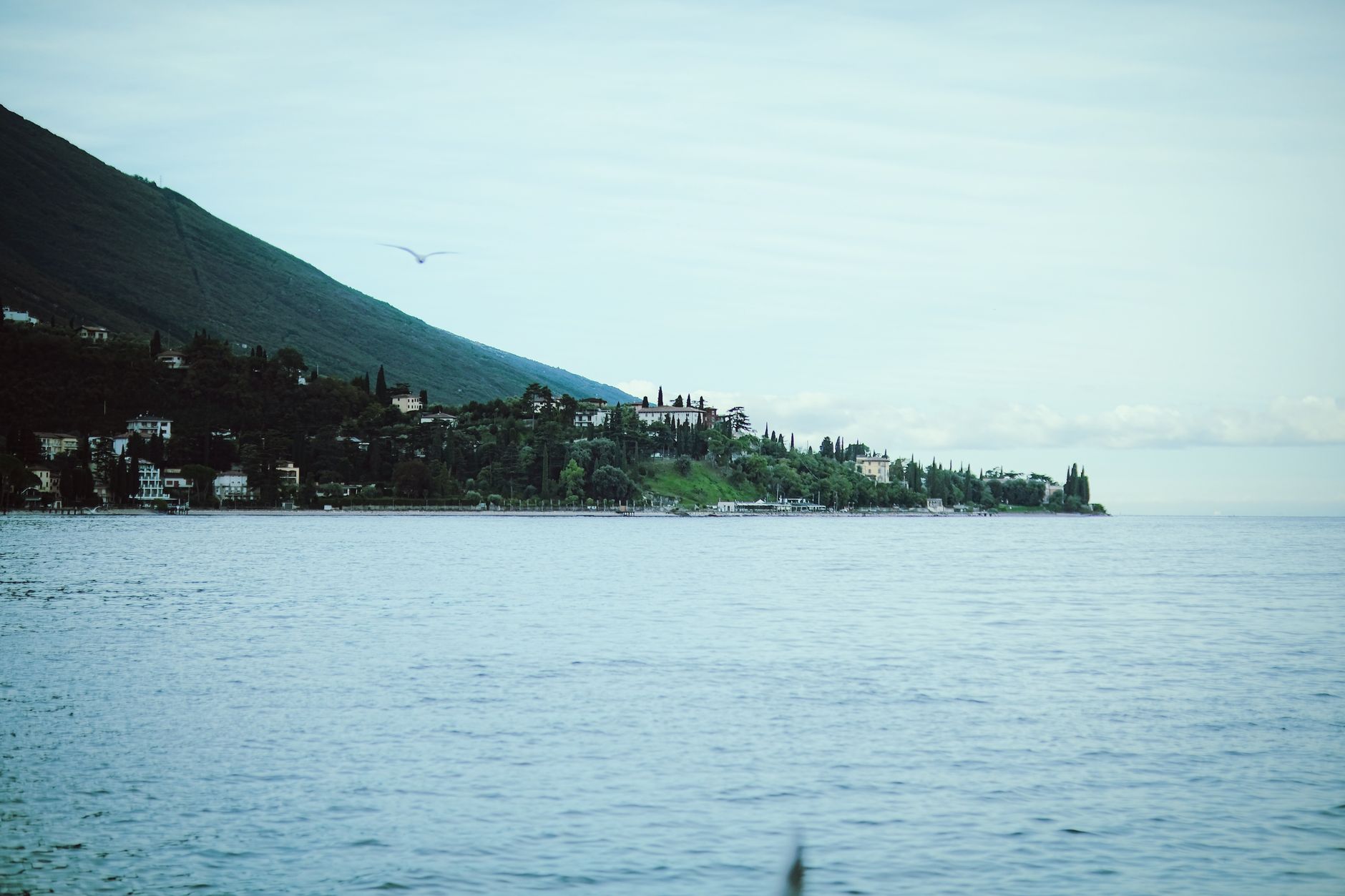 Picturesque landscape of Lake Garda with a distant island under a summer sky.