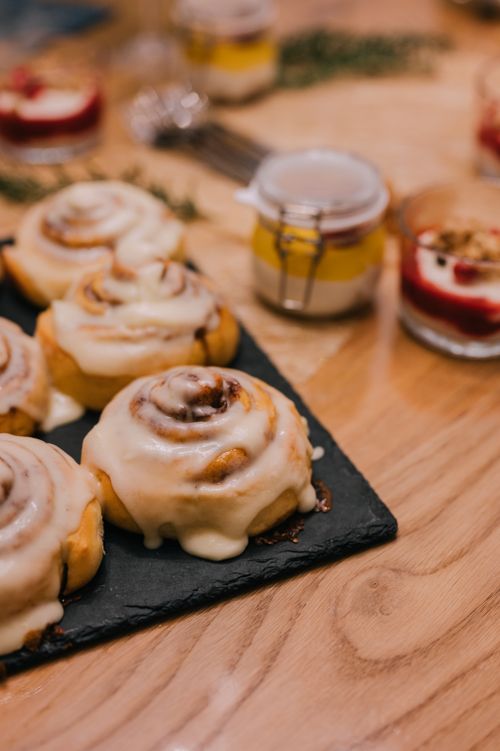 Free Close-up of mouthwatering cinnamon rolls topped with creamy icing, perfect for dessert lovers. Stock Photo