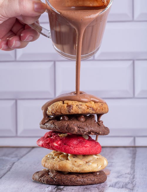 Woman Pouring Chocolate Sauce on Cookies 