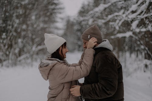Woman and Man in Jackets in Forest in Winter