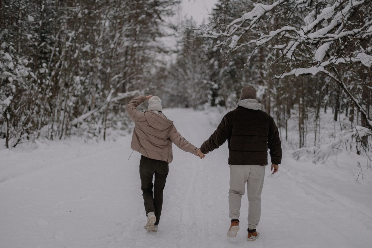 Couple holding hands on a snowy path