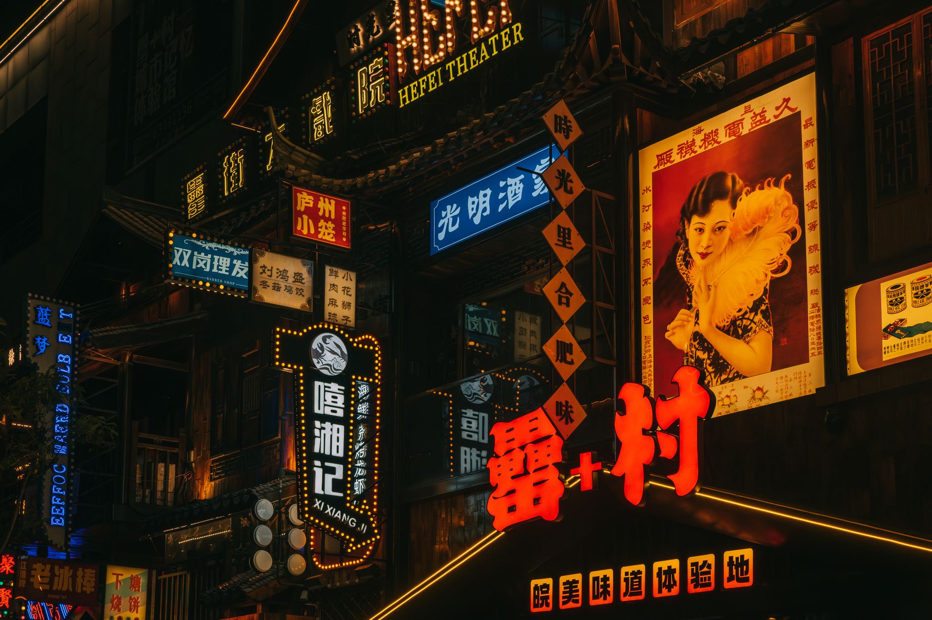 Vibrant urban nightlife with illuminated neon signs in Chinese script and bustling street scene.