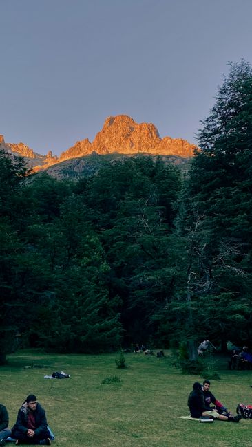 A serene landscape of mountains and people enjoying recreation in nature.