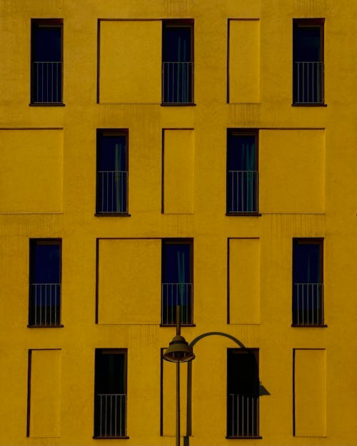 Free Yellow Wall with Dark Windows Stock Photo