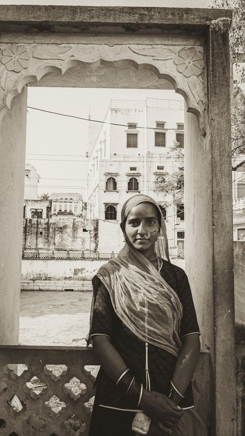 Free Elegant image of a woman in traditional attire framed by decorative architecture. Stock Photo