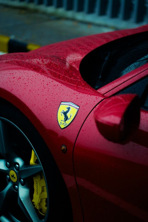 Free Detailed shot of a red sports car with logo in Malaysia. Rainy day highlights sleek design. Stock Photo